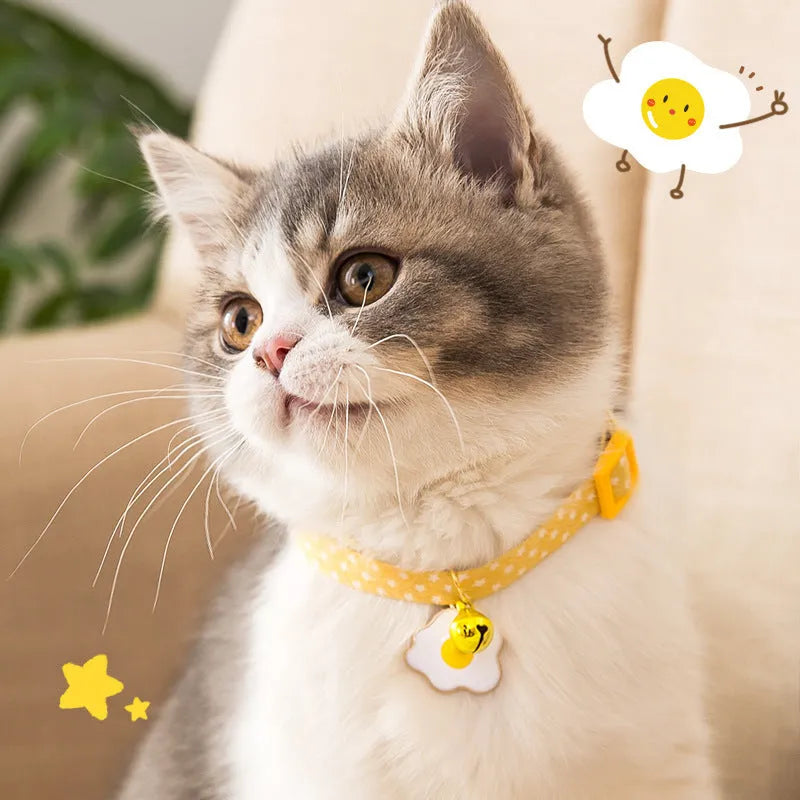 Green adjustable cat collar with silver bell and matching bow tie on a small dog