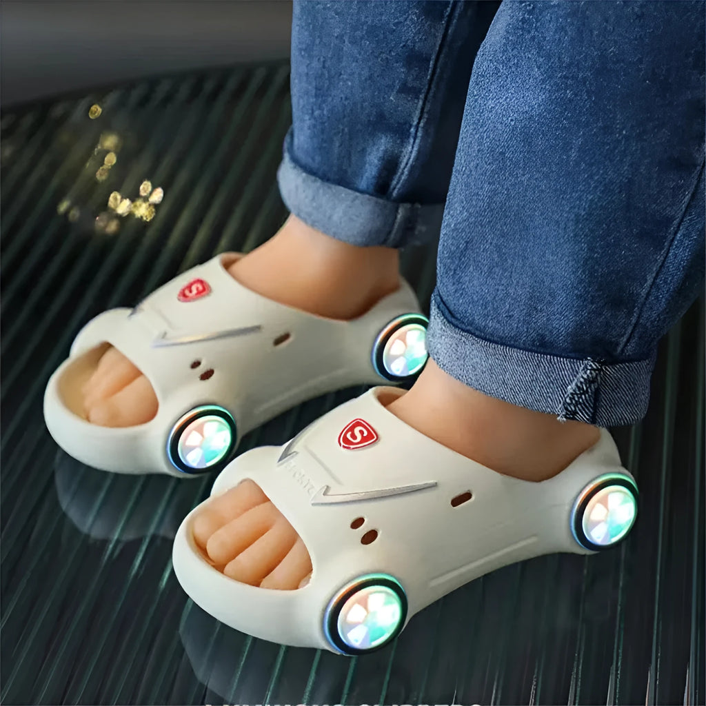 Children's luminous cartoon car design sandals with anti-slip soles on a blue background.