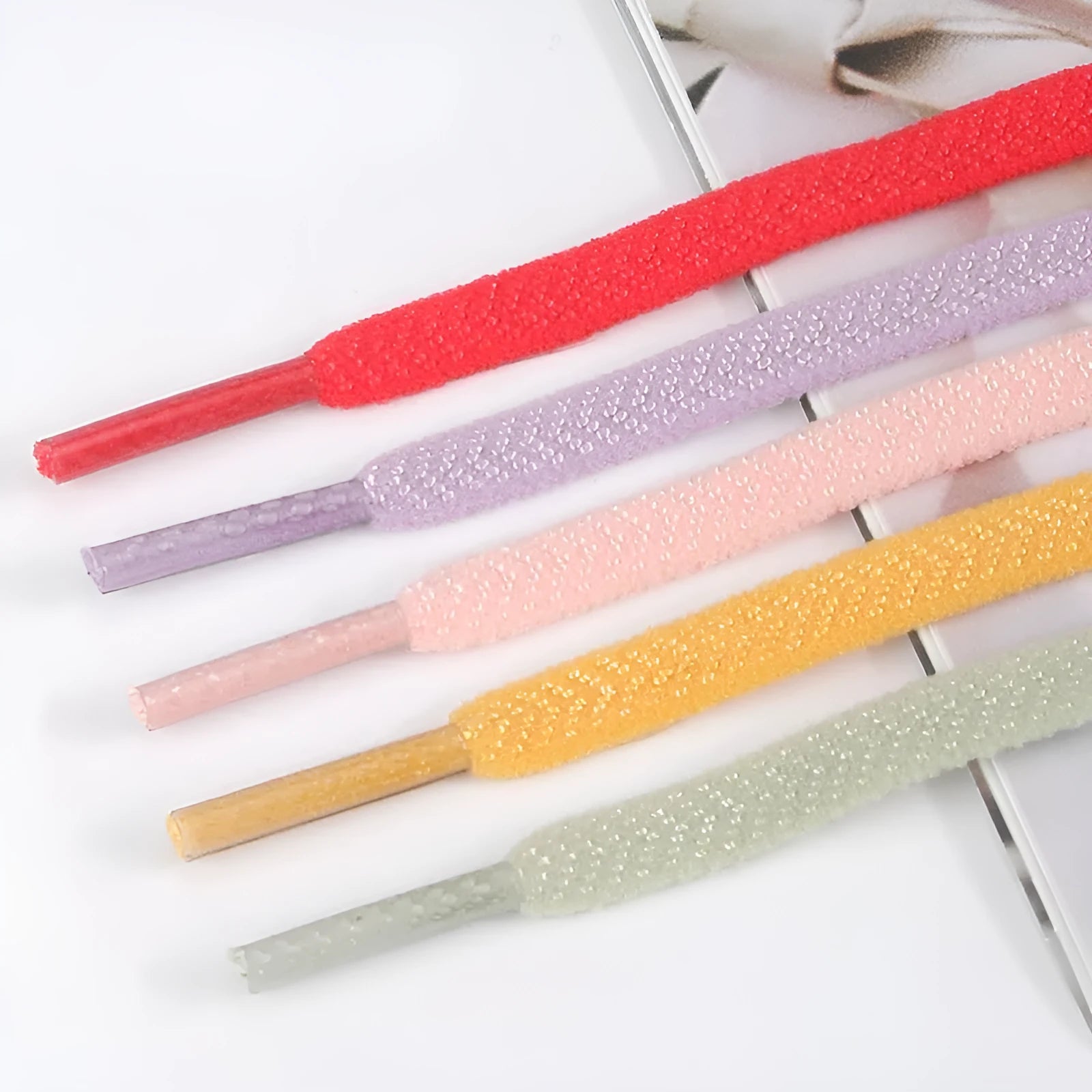Flat elastic arrow pattern colour shoelace in black, 0.6cm wide, laid flat on a surface
