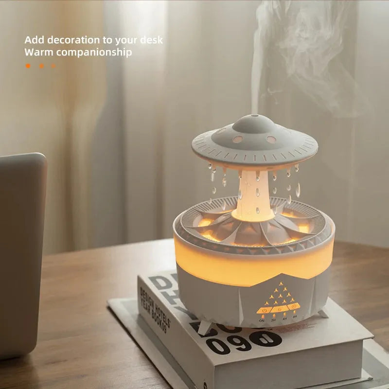 White cloud-shaped UFO raindrop humidifier diffuser with coloured night light on a wooden table.