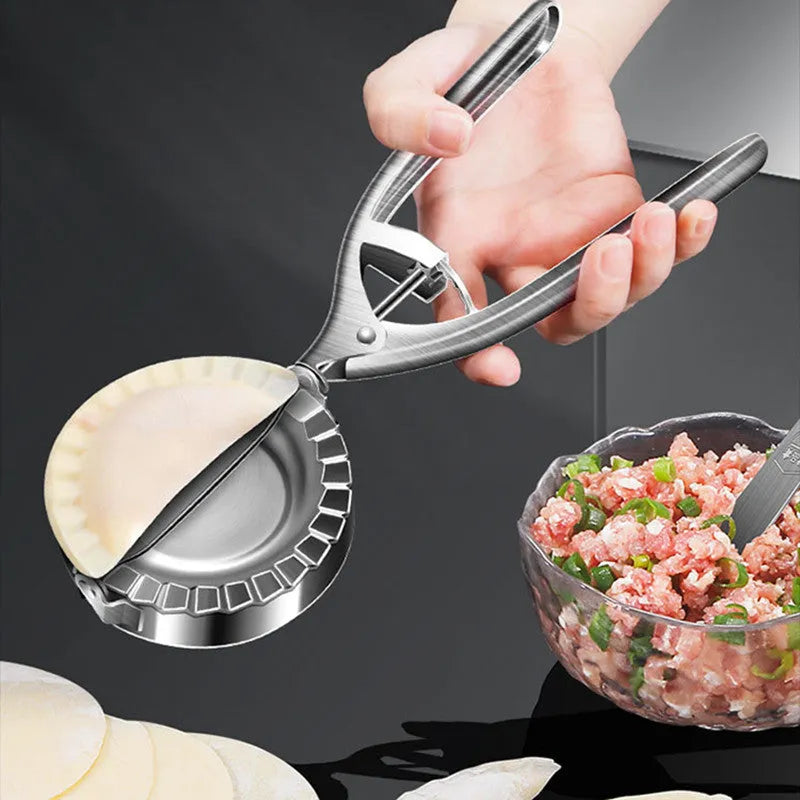 Silver stainless steel manual dumpling maker tool for pressing homemade dumplings.