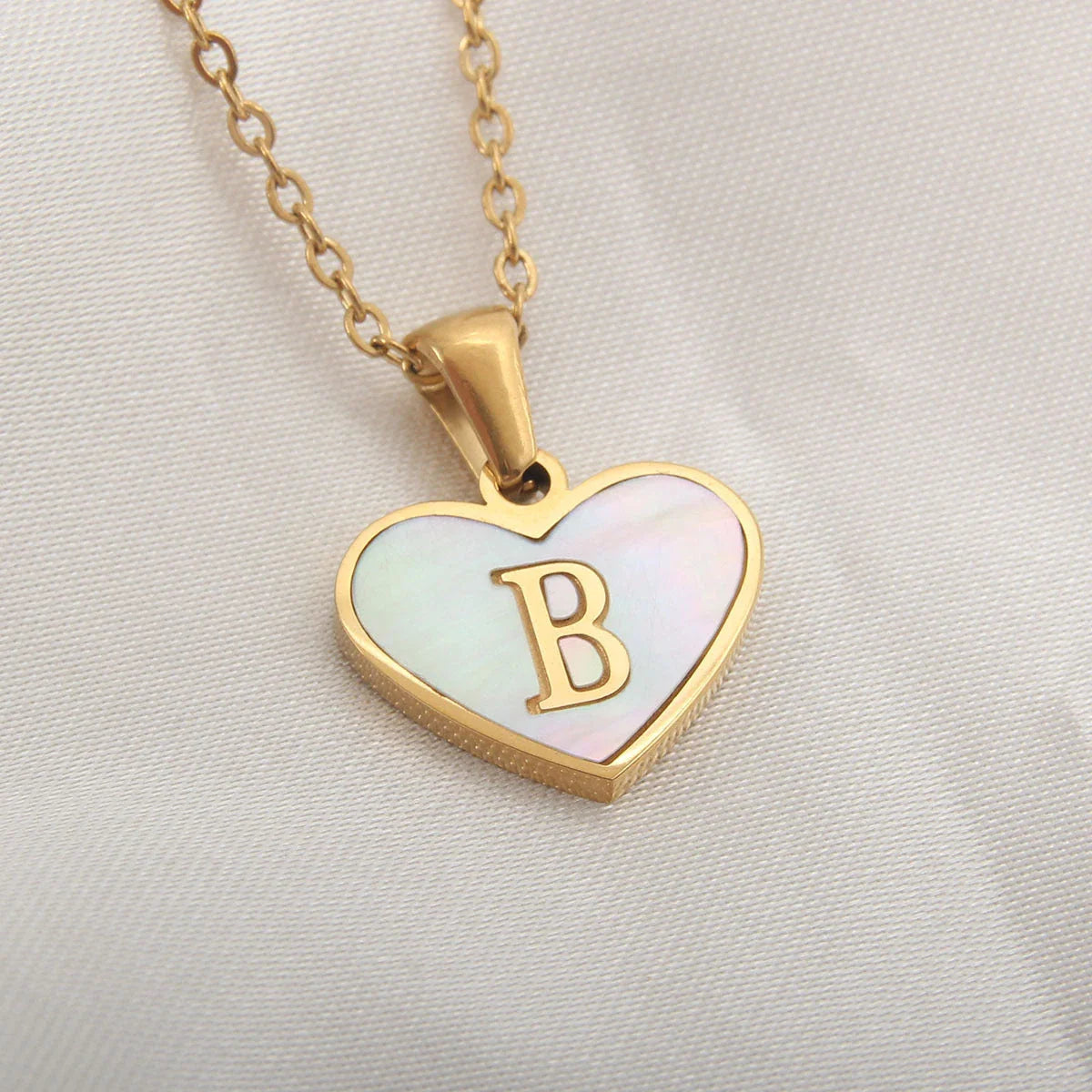 A personalized heart-shaped necklace with a 26-letter charm, crafted from high-quality stainless steel and gold plating.