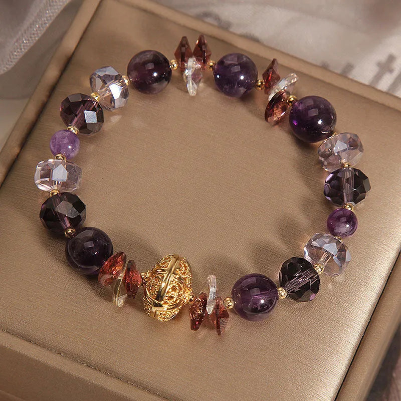 Purple crystal bracelet with pumpkin beads, wind chime charms, and rhinestone details on wrist