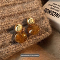 Three pairs of handmade geometric holiday earrings with tassel accents in different designs