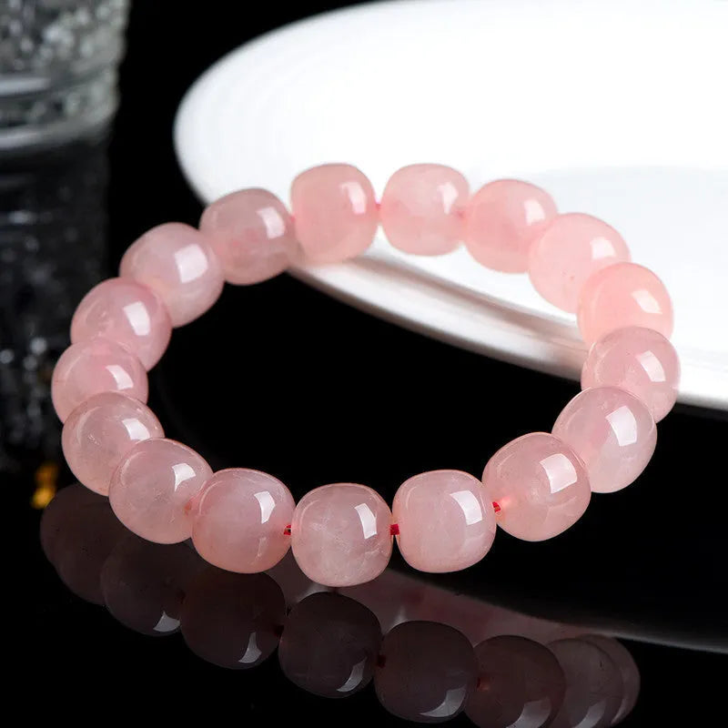Natural pink crystal barrel bead bracelet with geometric design on wrist