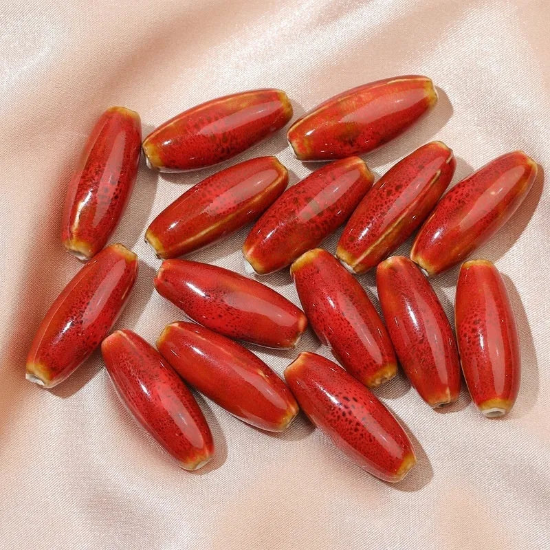 Ceramic bullet beads for jewellery making in various glaze colours including pink, yellow, blue, and red