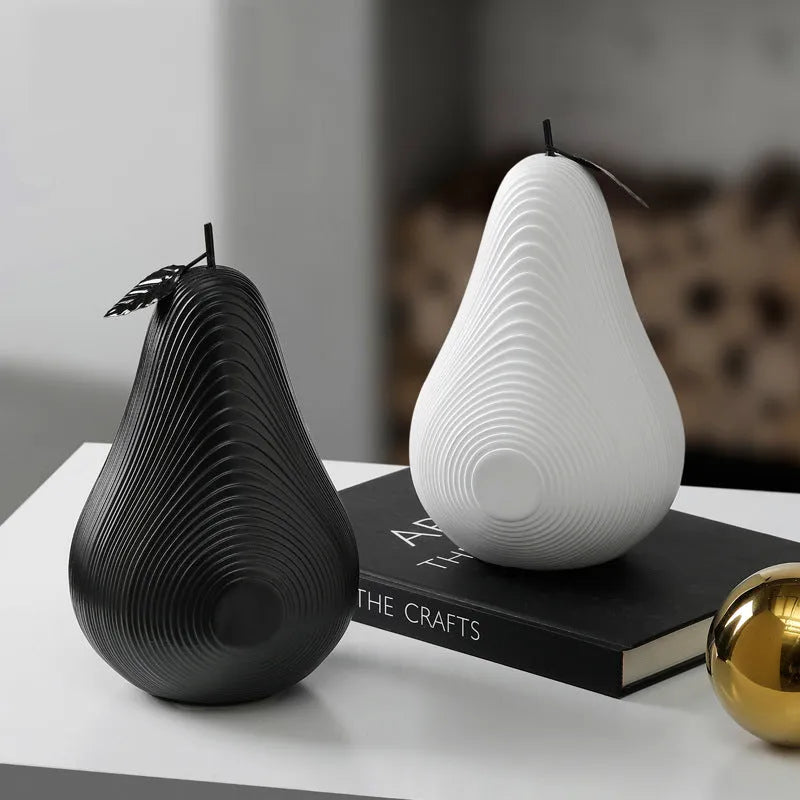 White and black resin apple and pear decorations showing high and low profile models on a wooden surface