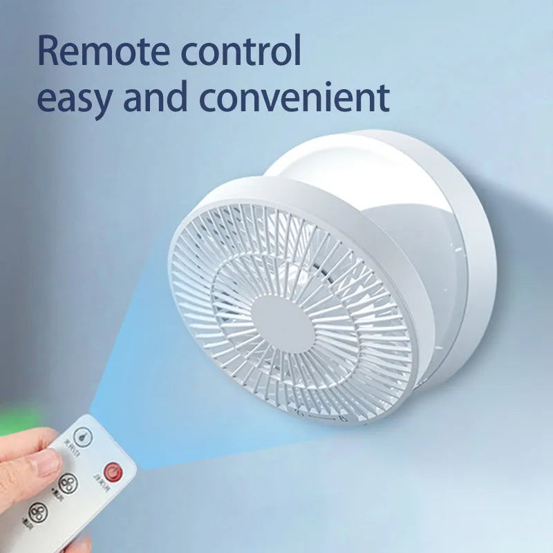 White rechargeable USB ceiling fan with remote control folded on a desk next to its charging cable.