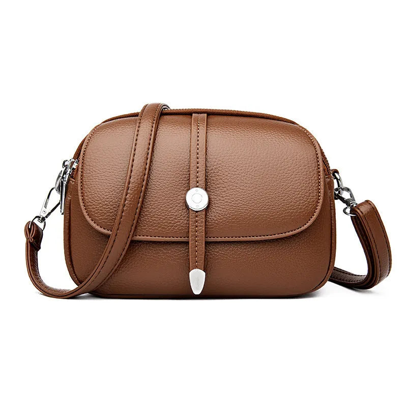Women's crossbody shoulder bag in oval suitcase shape with soft PU construction