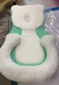 Folded portable baby travel bed with a soft beige cotton sleep cushion for newborns