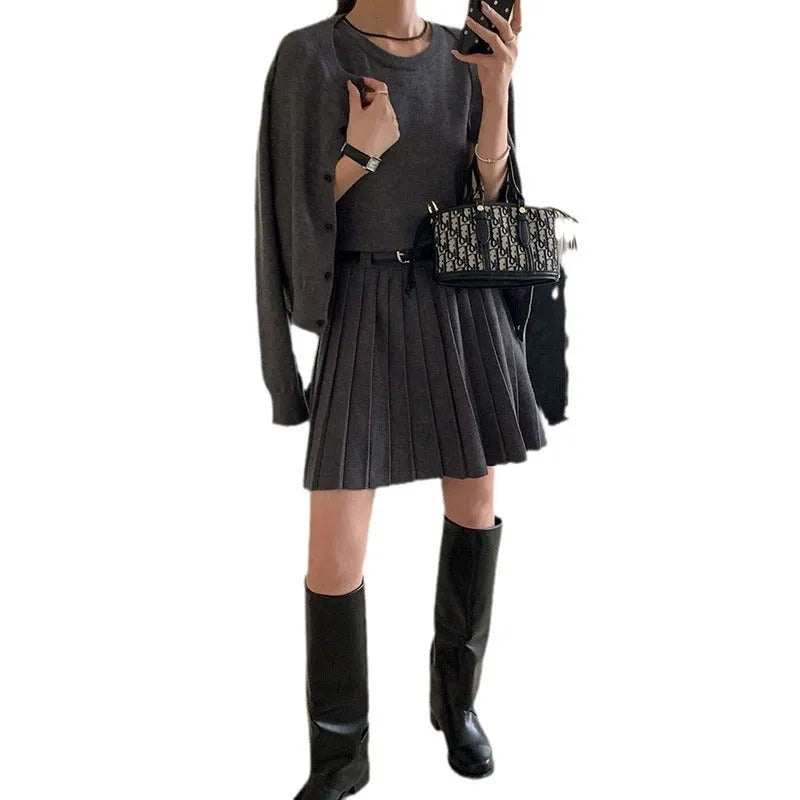 Women's black knitted vest skirt and long-sleeved cardigan two-piece set with pleats and a belt.