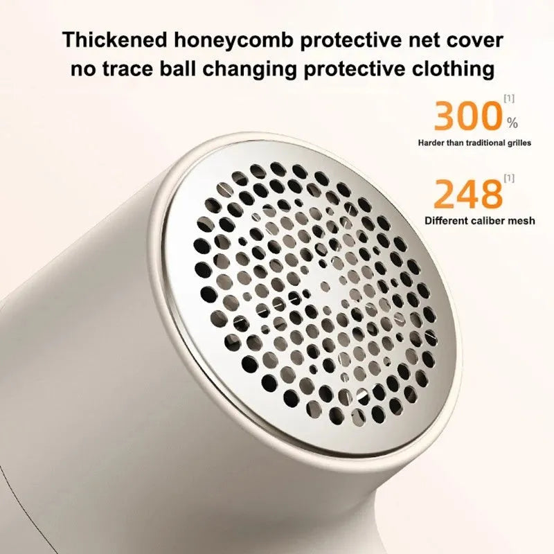 White electric lint remover with LED display, USB port, and stainless steel cutter head on a fabric background.