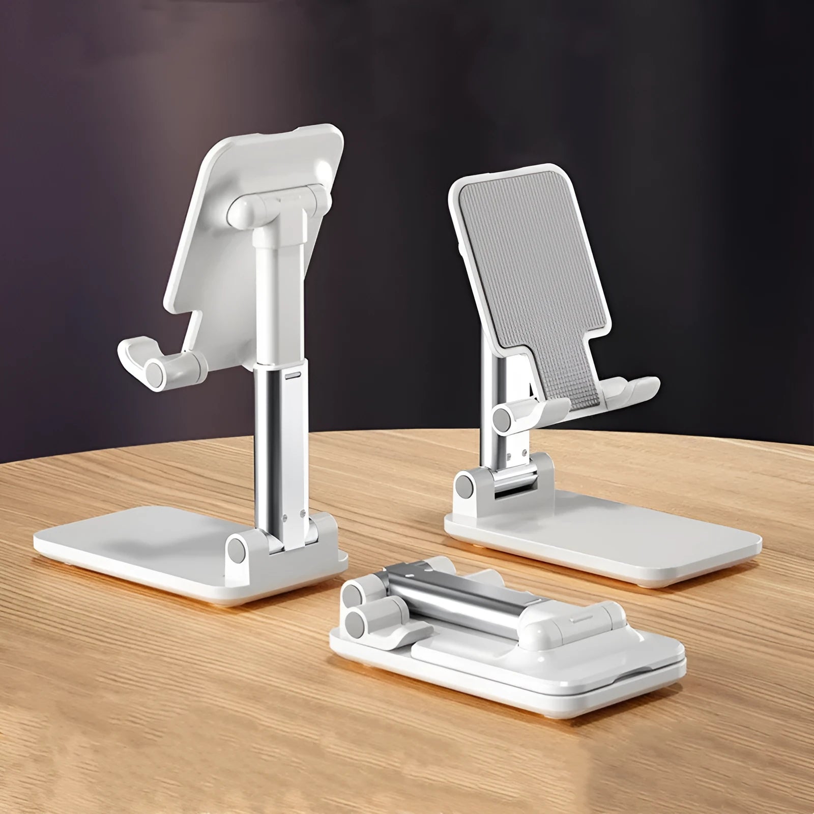 Folding telescopic mobile phone stand in white, blue, green, or pink on a desktop