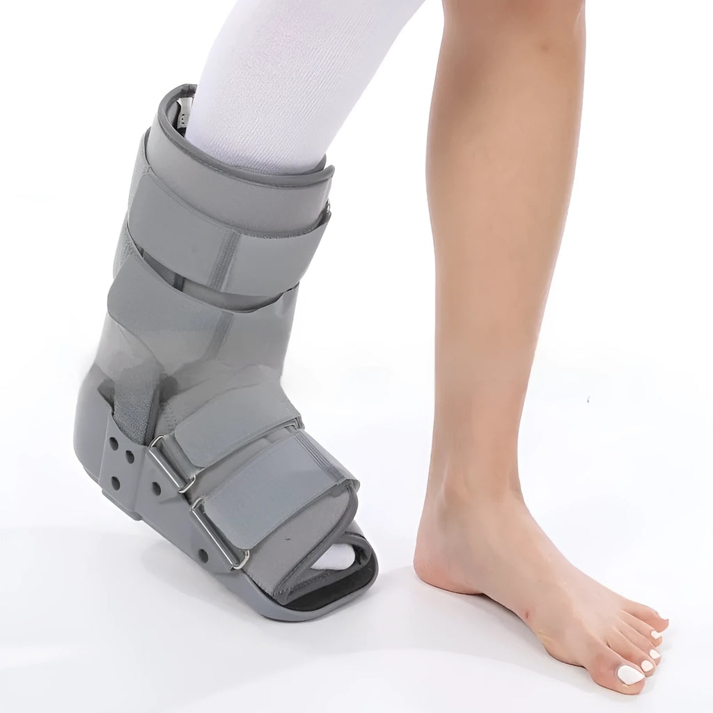 Grey Achilles tendon rehabilitation boot with aluminium frame and adjustable straps, shown with attached walking shoe.