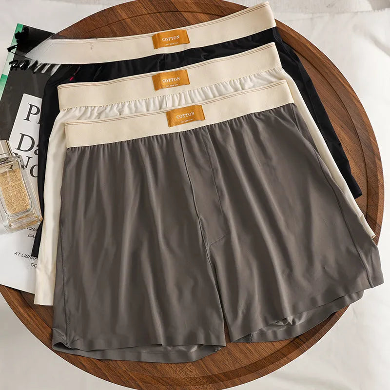 Pack of three pairs of men's solid colour loose fit ice silk nylon underwear on a white background.