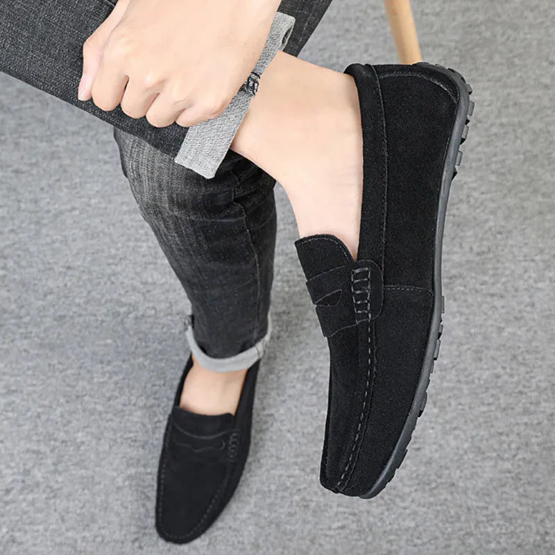 Men's brown suede slip-on loafers with round toe and flat rubber sole on a white background
