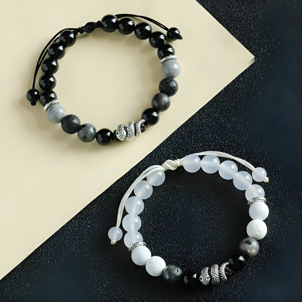 A matching couple bracelet set: one black agate and one white agate bracelet with snake chain clasps.