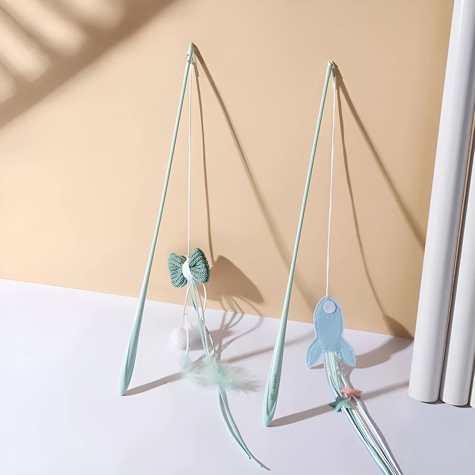 Long blue cat teaser wand with feathers and a pet rocket design on a white background.