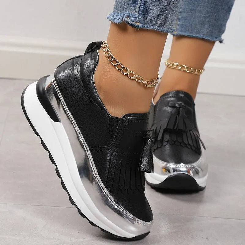 Women's black and white platform casual shoes with tassel detail and a muffin wedge heel