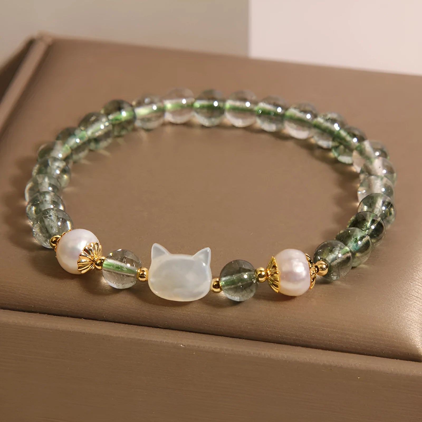 Green phantom quartz women's bracelet with a delicate shell kitten charm.
