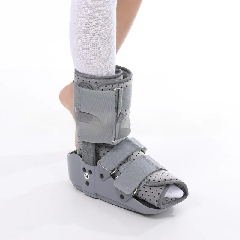 Grey Achilles tendon rehabilitation boot with aluminium frame and adjustable straps, shown with attached walking shoe.
