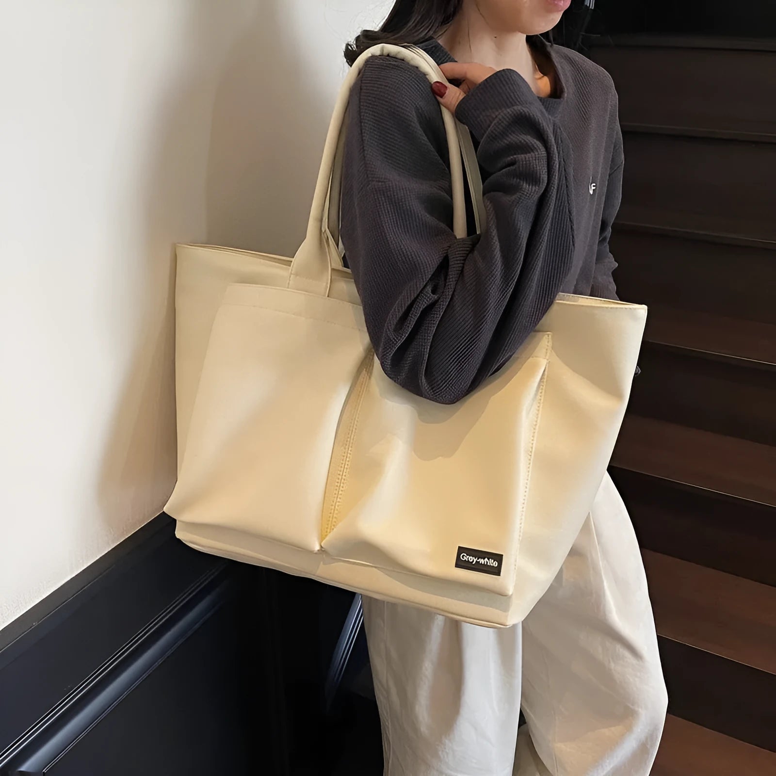 Lightweight solid colour PU shoulder bag shown in black, featuring an expandable design.