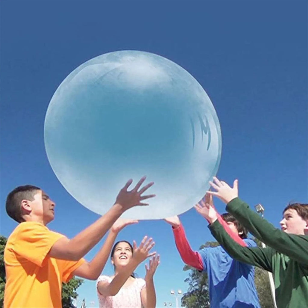 Large pink, yellow, green, and blue inflatable bouncy balls in different sizes for outdoor play.