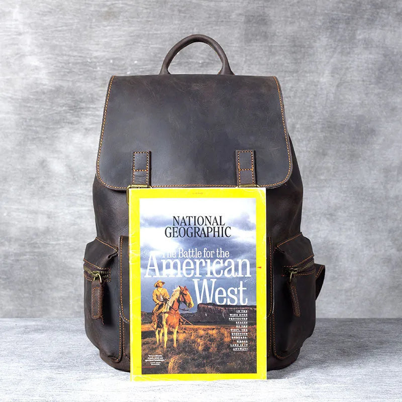 Brown genuine cowhide leather backpack with double shoulder straps and a soft handle.