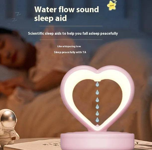 Love Anti Gravity humidifier, heart shaped with water droplet backflow, white colour, with ambience light, on a wooden desk