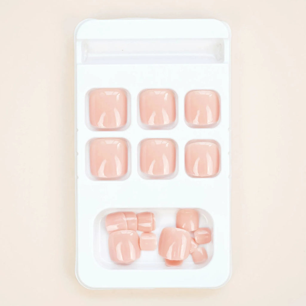 Plastic toenail stickers in skin colour with adhesive glue bottle on white background