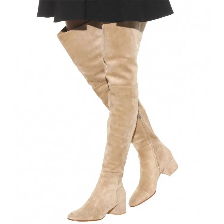 Women's grey suede over-the-knee flat boots with a pointed toe and low thick heel on a neutral background.