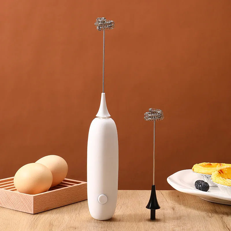 Hand-held electric milk frother and blender in black and white colour options on a kitchen counter.