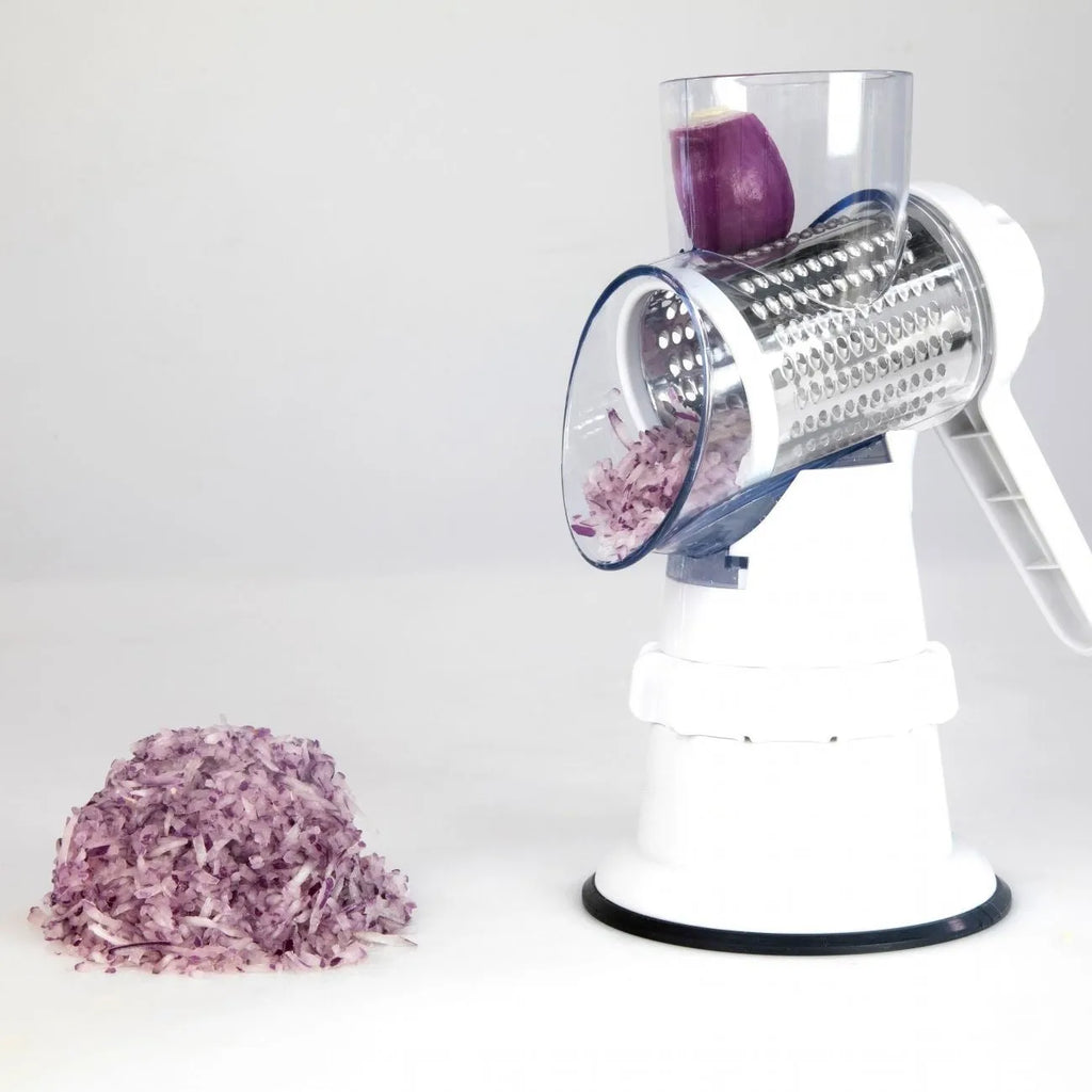 White 3-in-1 manual vegetable slicer and grater with suction feet on a kitchen counter.