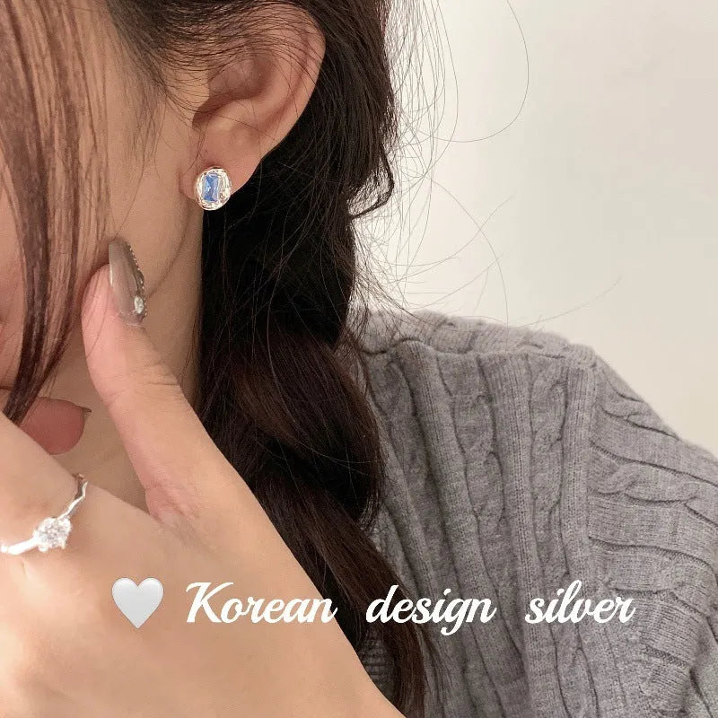 S925 sterling silver earrings with heart-wrapped oval design and blue diamond detail