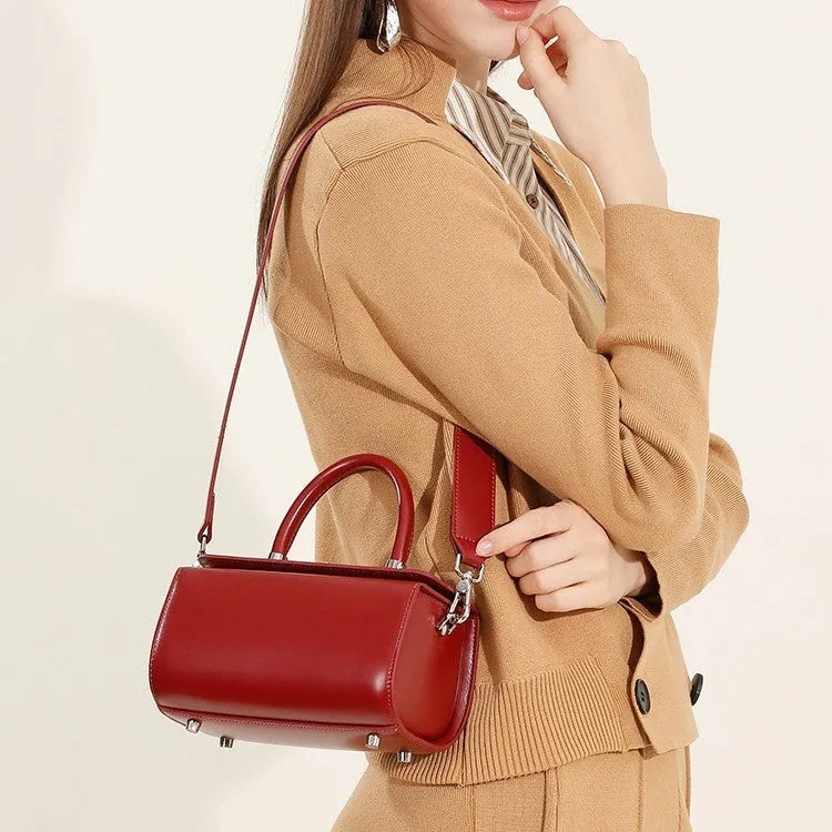 Brown leather women's crossbody bag with a single shoulder strap and clamshell opening.