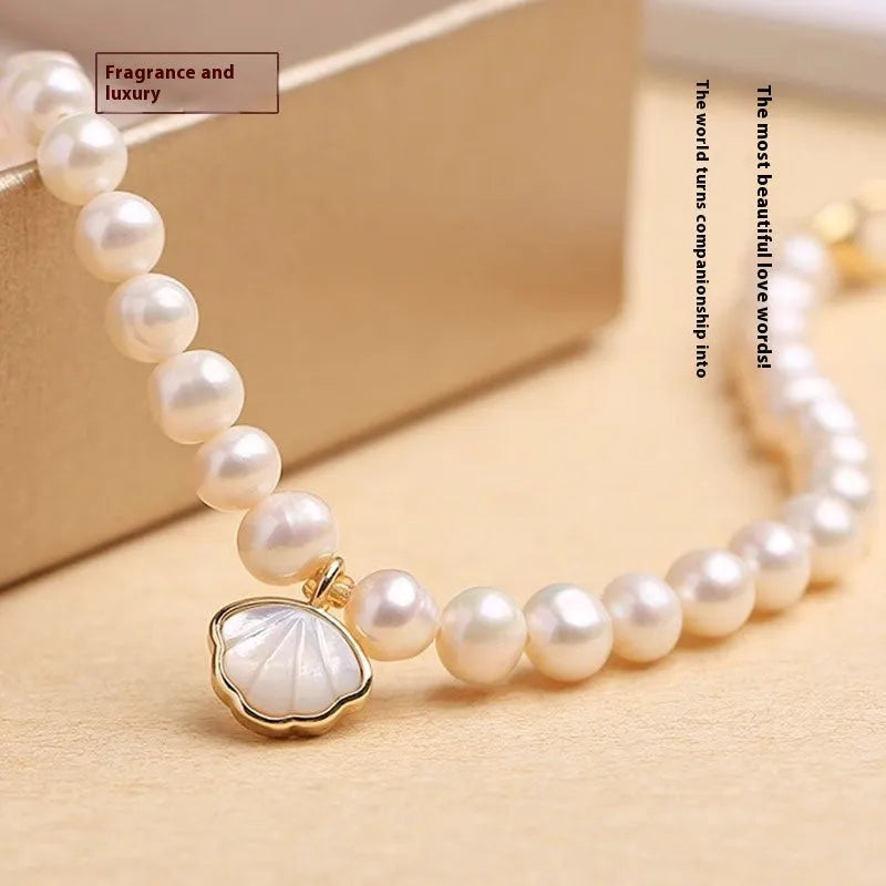 Women's freshwater pearl bracelet with fan-shaped design on a wrist, showing elastic and chain fastening options.