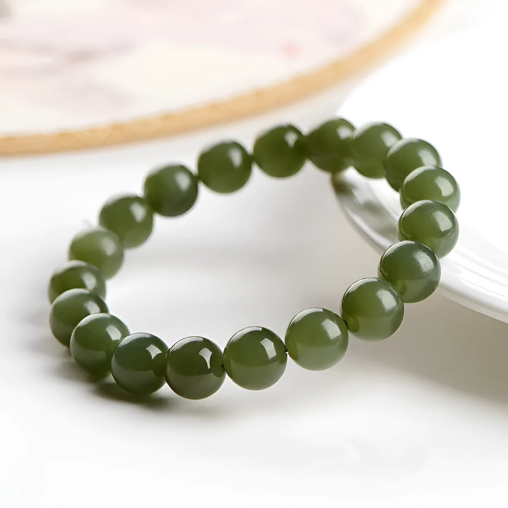 Hand-polished Hetian jade ball bracelet on wrist, showing deep water clear beads.