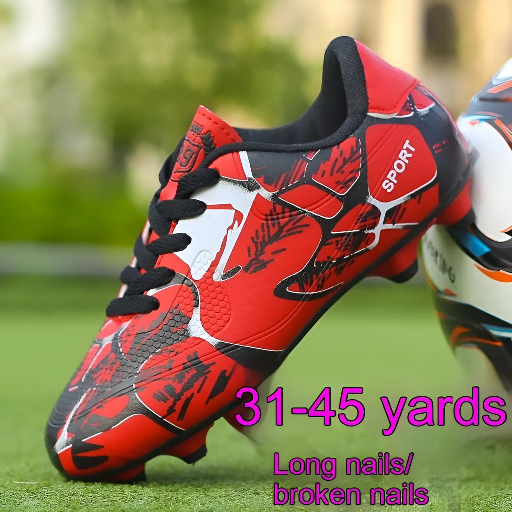 Red low-top soccer shoes with synthetic leather upper and spike outsole on natural grass