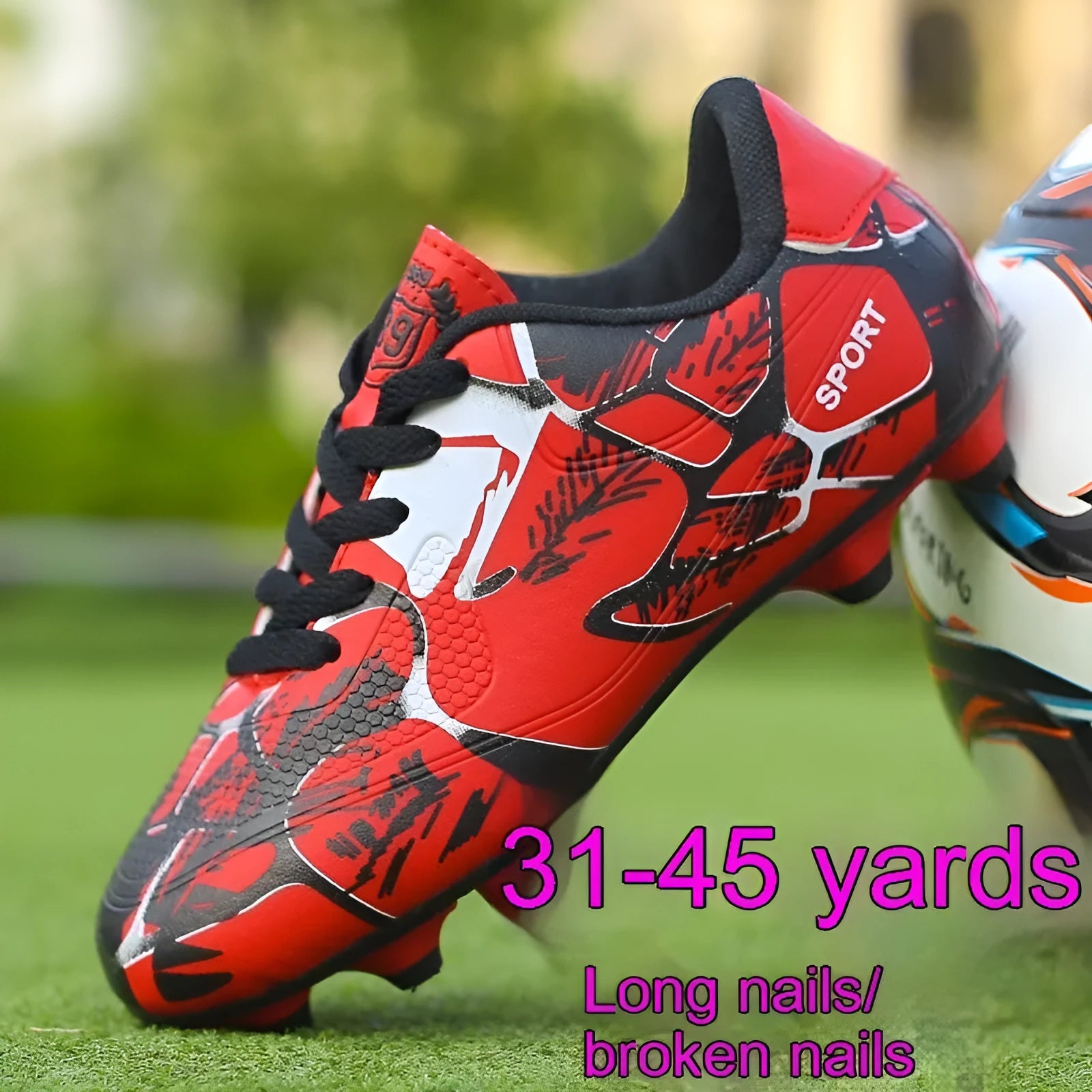 Red low-top soccer shoes with synthetic leather upper and spike outsole on natural grass