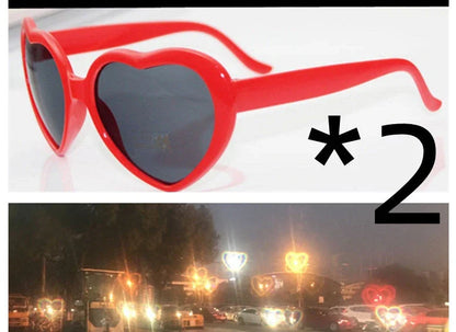 Heart-shaped glow-in-the-dark sunglasses in various vibrant colors, featuring a durable plastic frame and resin lenses for reliable UV protection.