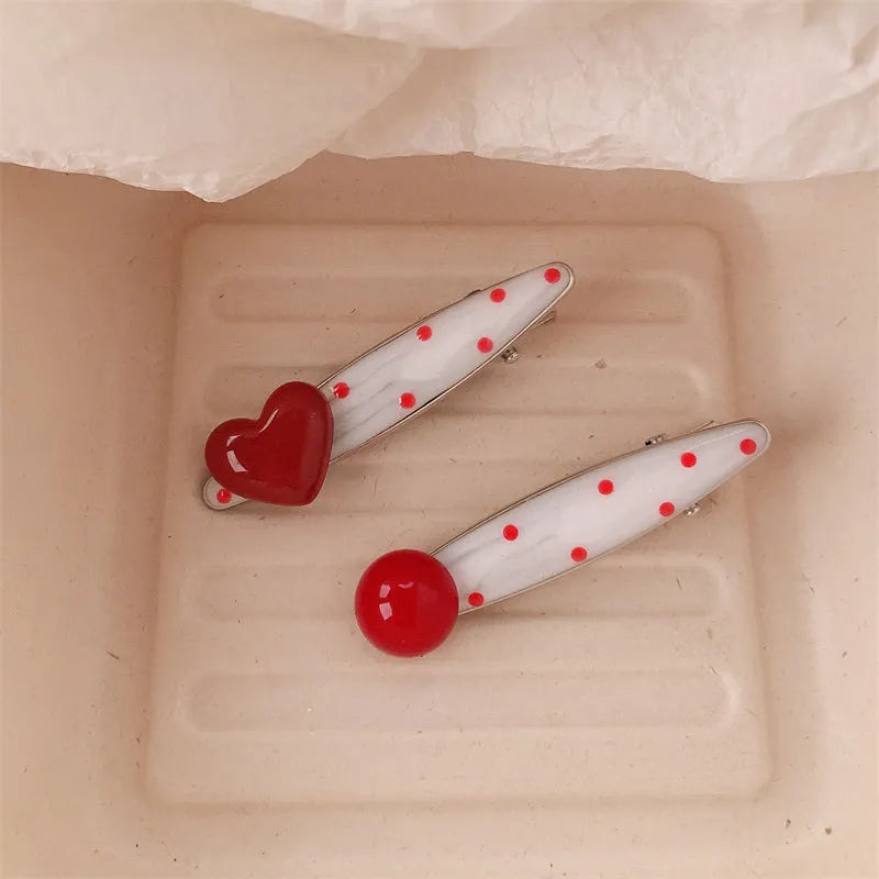 Red love heart shaped hair clip with dotted patterns and willow leaf designs on a barrette