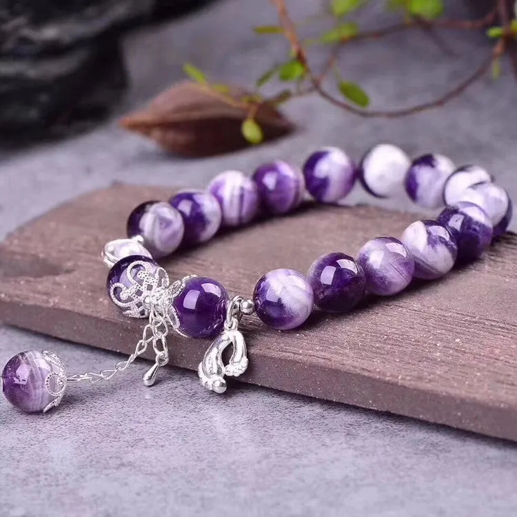 Natural amethyst bracelet with 10mm round beads on a woman's wrist.
