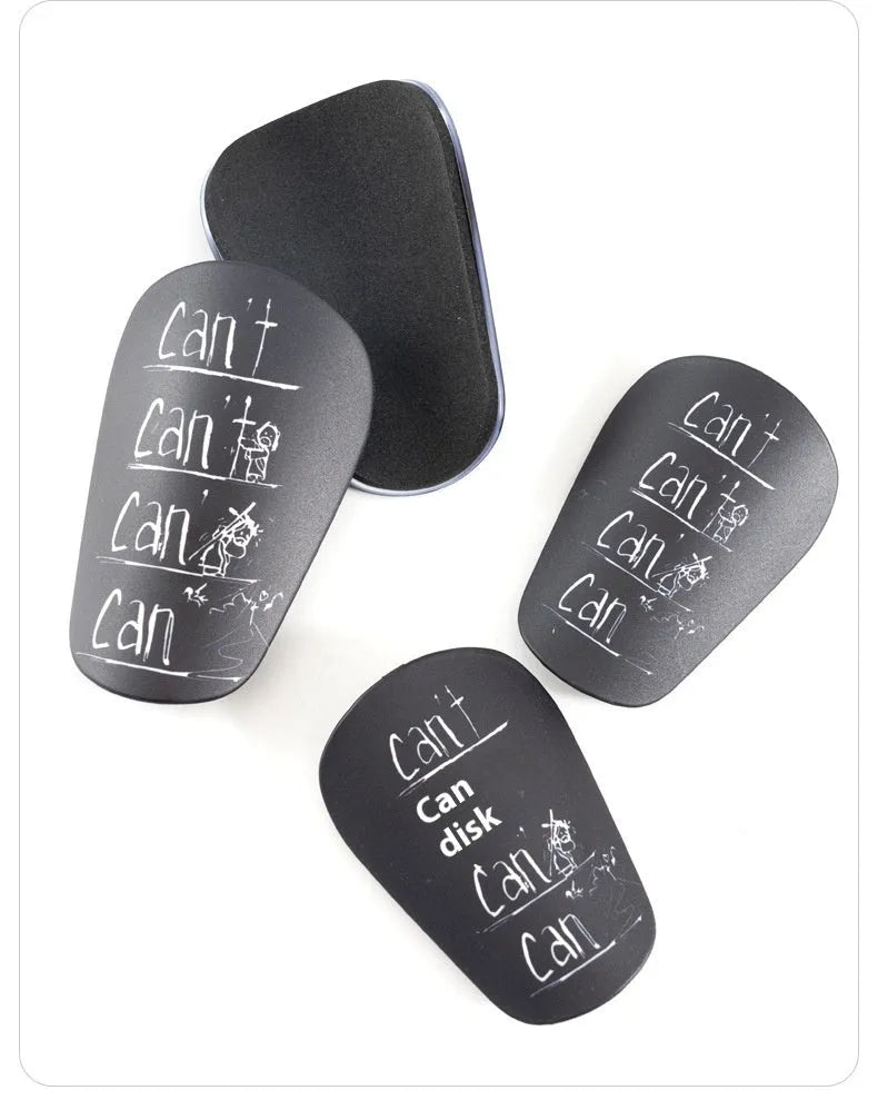 Pair of PU football shin guards in black, shown on a leg, for training and sports protection.