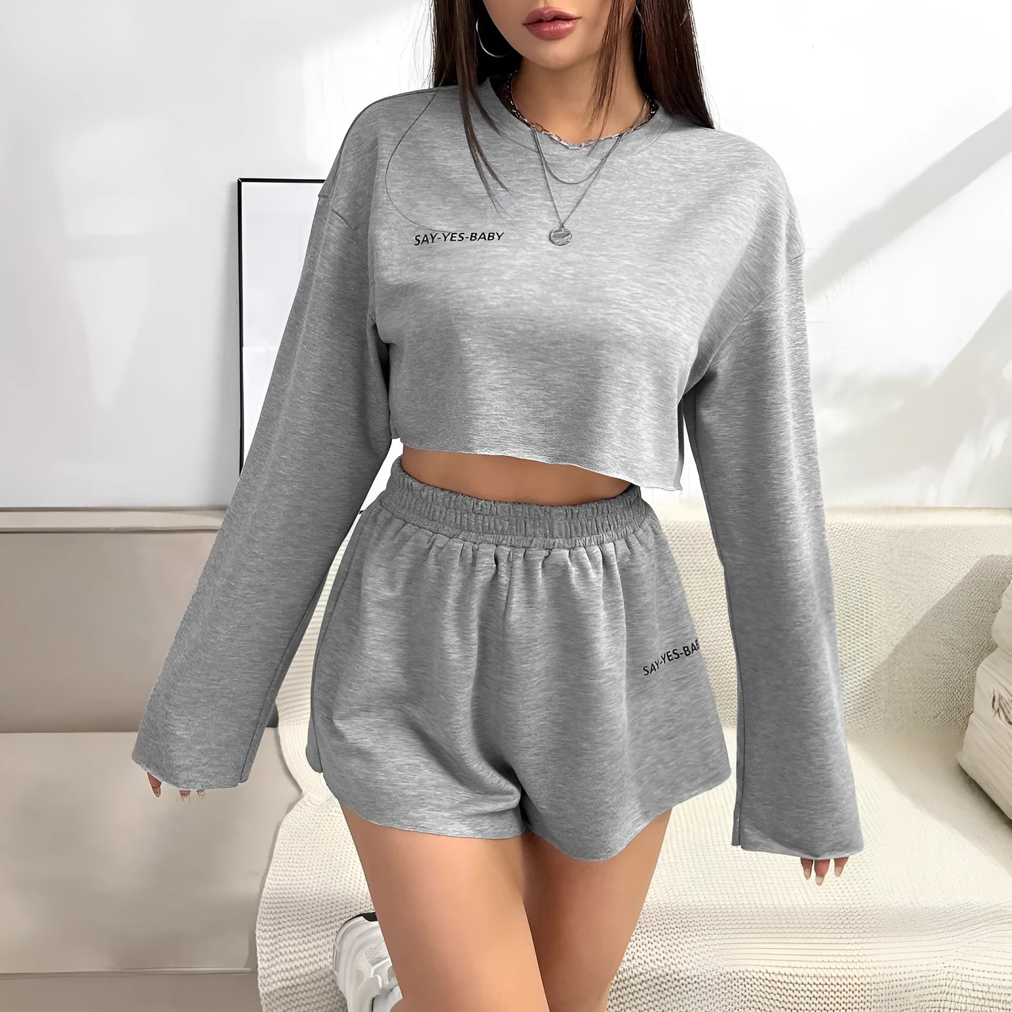 Grey women's long-sleeved T-shirt and matching shorts lounge set laid flat