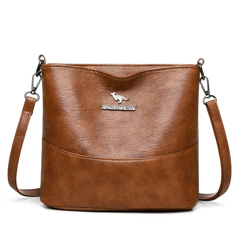 Women's PU leather crossbody bucket bag with wide strap, outer slit pocket, and internal phone and file pockets.