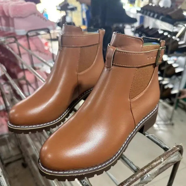 Women's round toe ankle boots with a belt buckle detail on the upper, shown in black.
