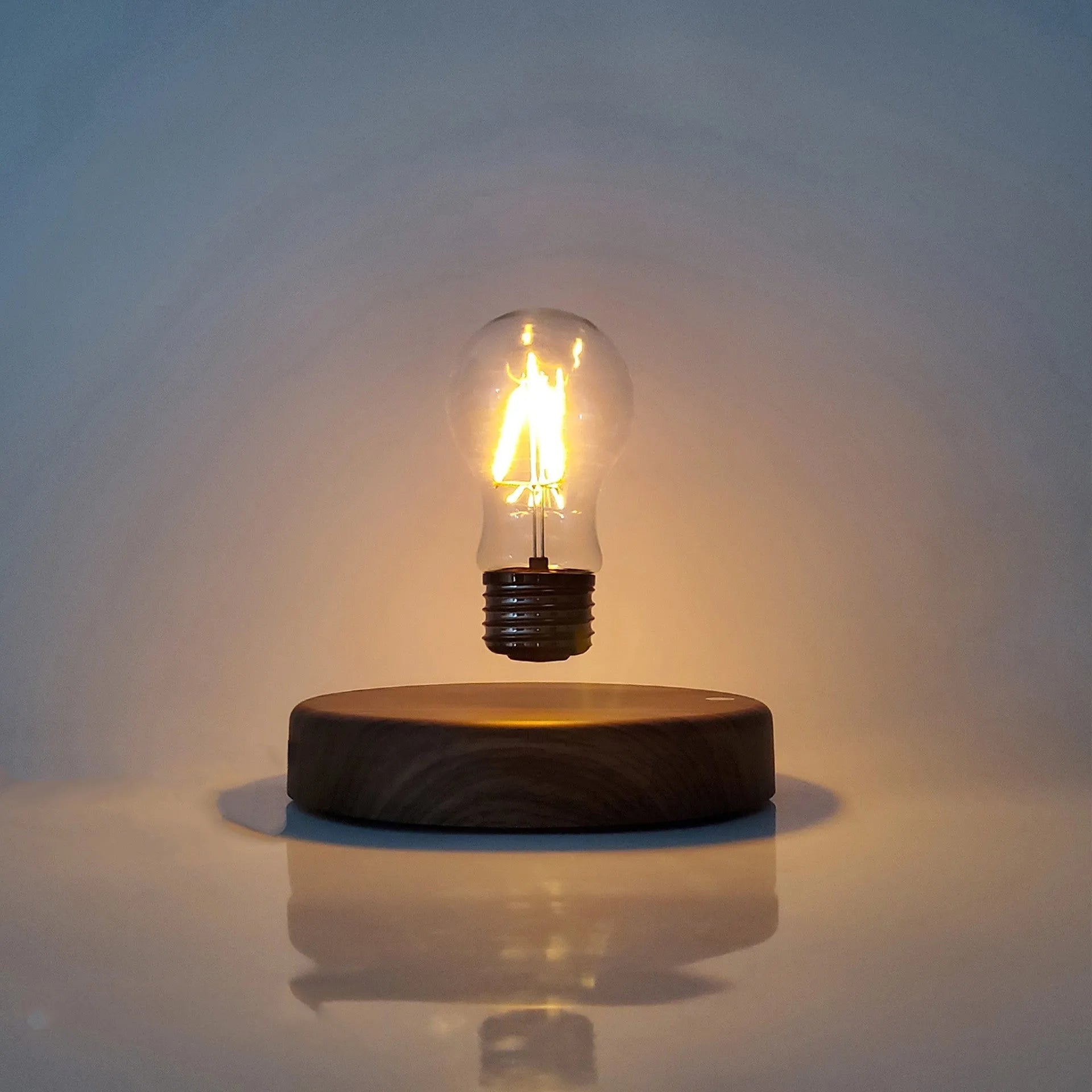 Magnetic levitation bulb night light in solid wood colour floating above desktop base