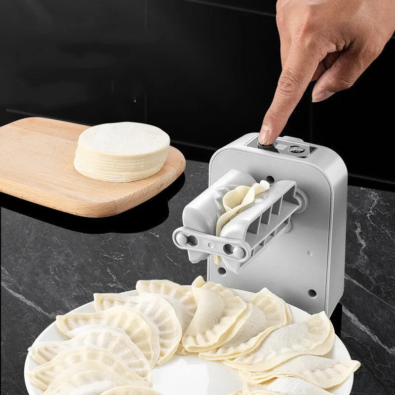 White automatic electric dumpling maker machine with USB cable and accessories on a kitchen counter.