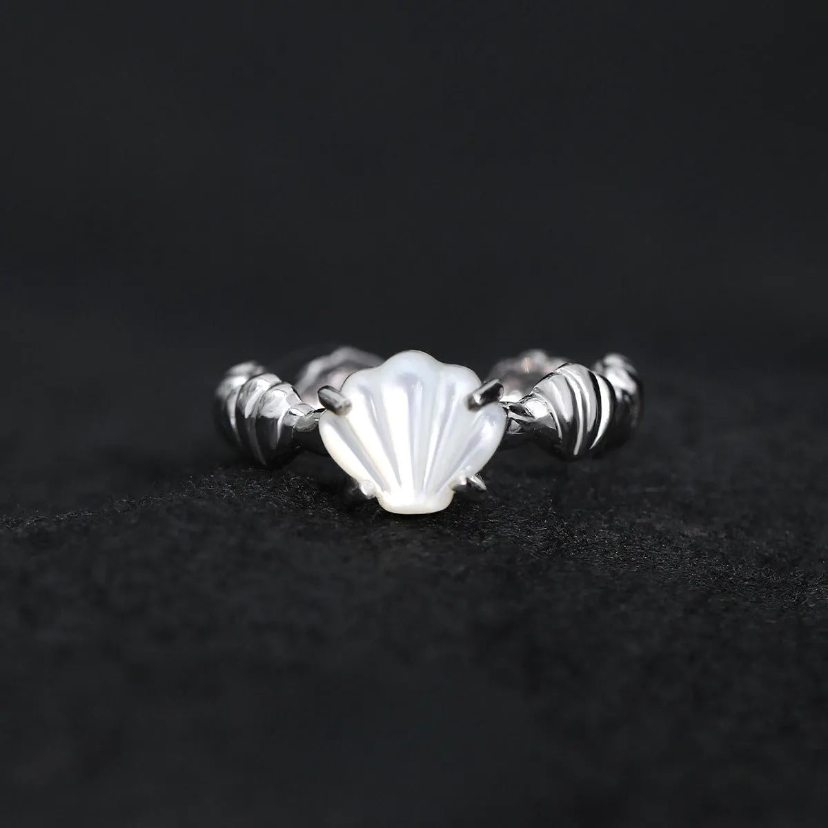 Adjustable silver ring with a shell design and tiger eye stone in white gold or gold finish.