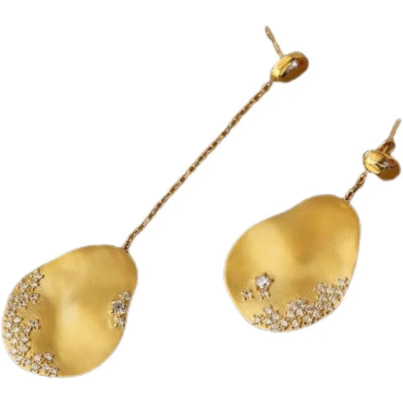 A pair of asymmetric gold-plated flower earrings with zircon detail, shown in silver and gold colour options.